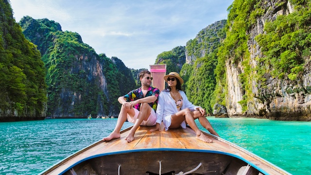 couple,in,front,of,longtail,boat,at,the,lagoon,of couple,in,front,of,longtail,boat,at,the,lagoon,of